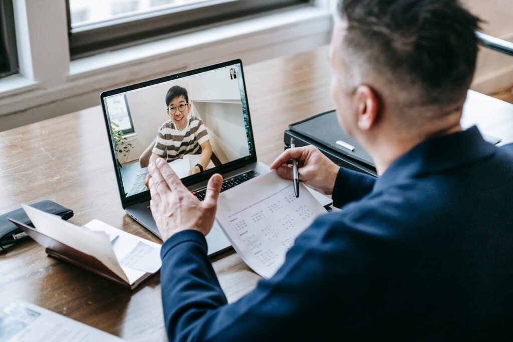 The Art of Drawing Readers In: Your attractive post title goes here A professional having a video conference on a laptop from a home office, engaging in online communication.